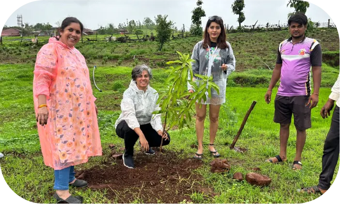 Volunteers standing with planted saplings in open field
